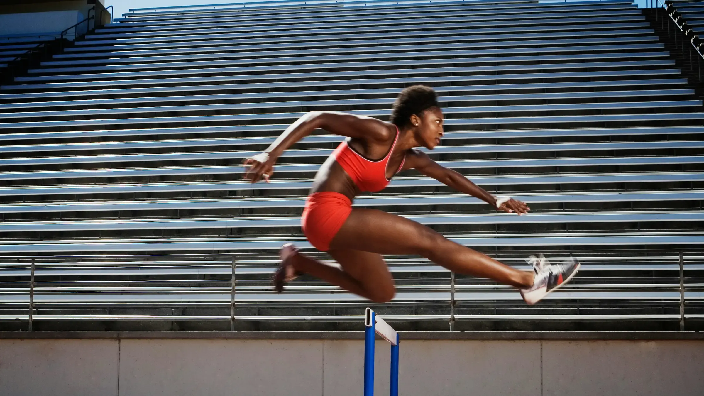 Athlete clearing a hurdle on an empty running track